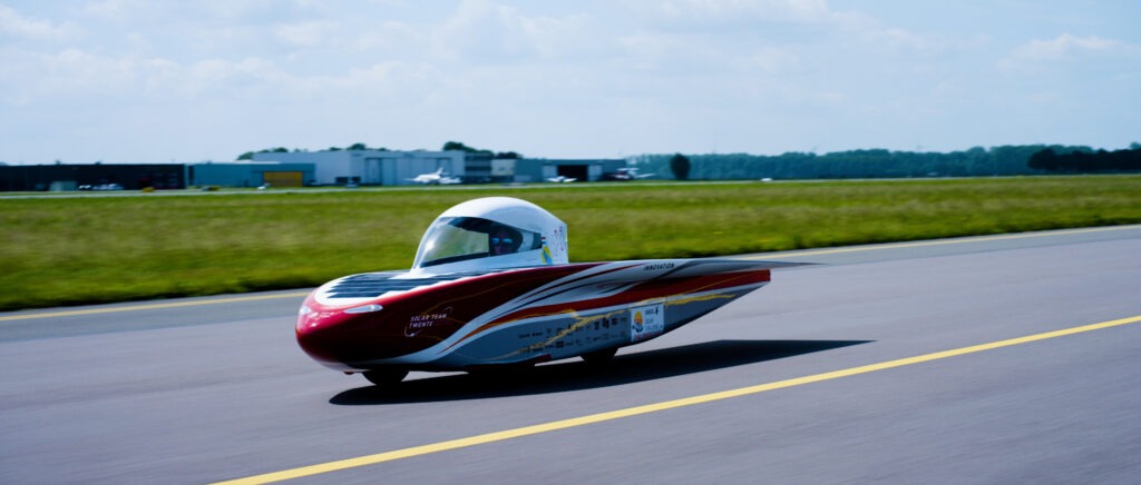 Actiefoto van de zonneauto van Solar Twente op de lange baan van Lelystad Airport