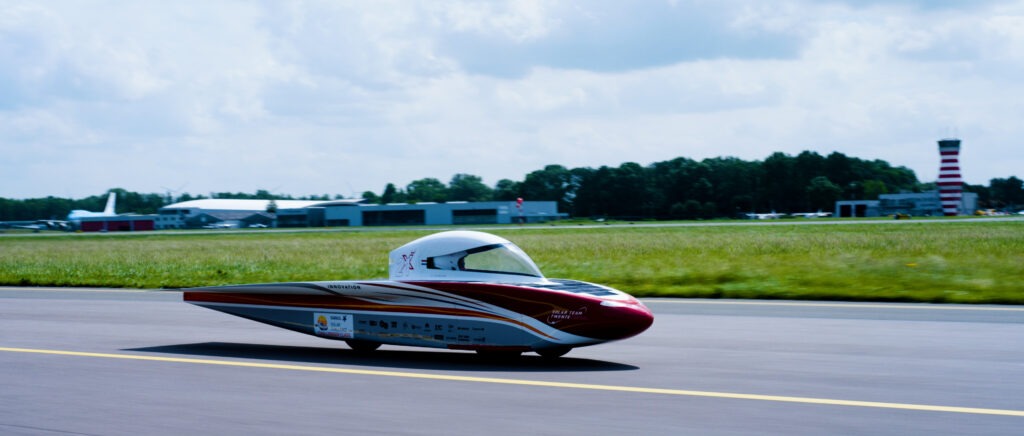 Actiefoto van de zonneauto van Solar Twente op de landingsbaan van Lelystad Airport
